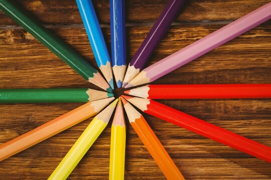 Color pencils arranged on wooden table