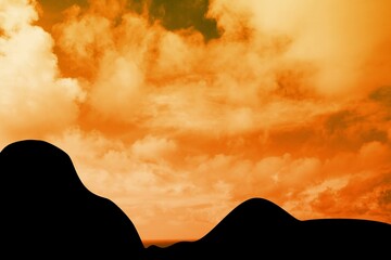 Flat design silhouette dunes are standing against glowing orange sky with scattered cloud shapes