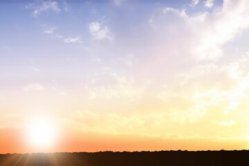 Glowing sun orb is rising over silhouetted terrain in flat design, with wispy clouds, pastel sky