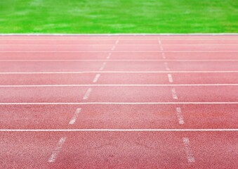Flat design is illustrating red running track with white lane markings bordered by green grass