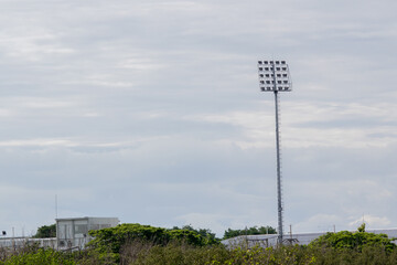 Tall Stadium Light Tower Against Cloudy Sky