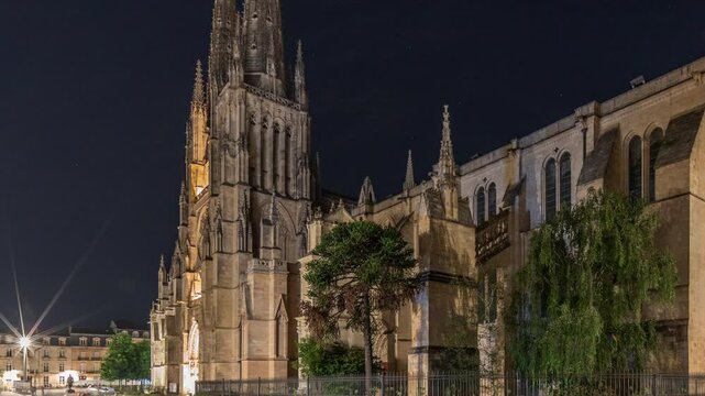 Cathedrale Saint-Andre de Bordeaux night timelapse hyperlapse with twin spires. Illuminated buildings and trees on the Pl. Pey Berland square create an evening urban atmosphere. Bordeaux, France