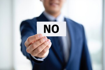 A Business Professional Holding a Card Indicating Rejection, Signifying Firm Decision-Making and Assertiveness in Corporate Environments