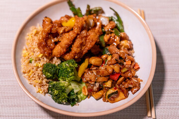 Close-up of colorful Chinese takeout with chopsticks on a rustic wood table, showcasing vibrant stir-fry noodles, vegetables, and dumplings—perfect for food blogs, menus, or cultural features.