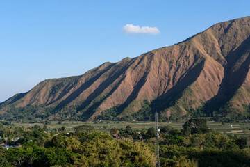 Majestic view of Pergasingan Hill glowing under soft morning light, seen from Selong Hill in Sembalun, Lombok—where dramatic ridgelines meet tranquil rural charm.