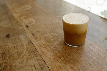 Cup of creation froth coffee on rustic wooden background. Selective focus.