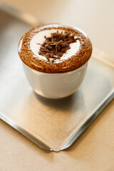 Cup of hot milk chocolate mocha coffee on table by the window.