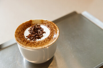 Cup of hot milk chocolate mocha coffee on table by the window.