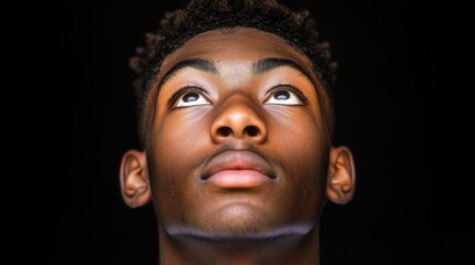 The contemplative stare of a curly-haired man is fixed on something above