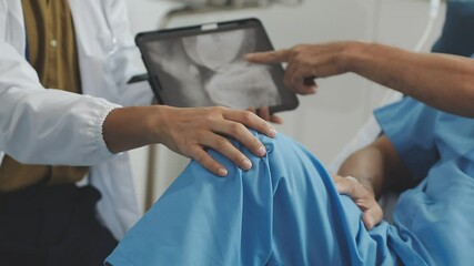 Asian male doctor examining knee of female patient sitting on nursing bed She holds a cane to help her walk. Concept of osteoarthritis, knee pain, osteoarthritis, knee inflammation. Physical therapy - Powered by Adobe