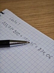 Add expenses in a notebook, count costs, square notebook