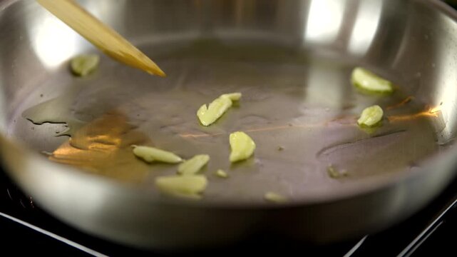 Sliced Garlic Cloves Saut&eacute;ing In Hot Oil Inside Pan