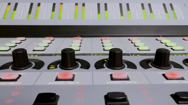 A blinking light of a button knob, metrix meter level was running of a sound mixer panel control.