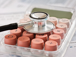 Stethoscope resting on calculator is calculating healthcare costs