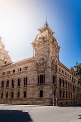 Palacio de Justicia de Barcelona, an ornate historic courthouse with neo-Gothic architecture, stands prominently under a clear blue sky.