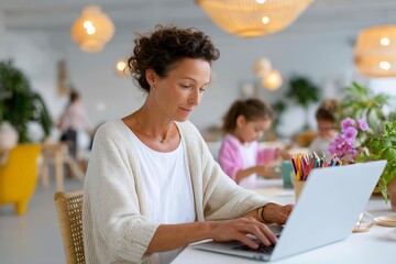 Caucasian female adult working remotely with children in creative workspace
