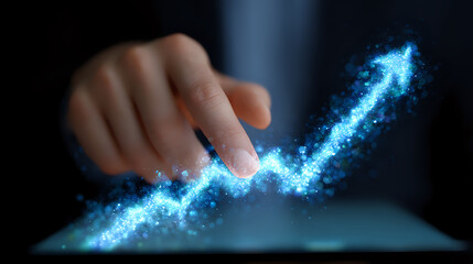 Glowing blue digital graph line emerges from tablet screen as finger touches interactive display, showing business growth and technological advancement in dark setting.