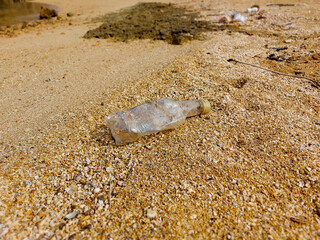 Plastic bottles on sandy beach, used plastic bottles thrown on the beach. Polluted trash left by visitors.