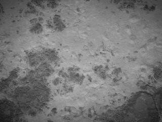 Textured cement with darkened spots and a few cracks, creating an aged concrete look.