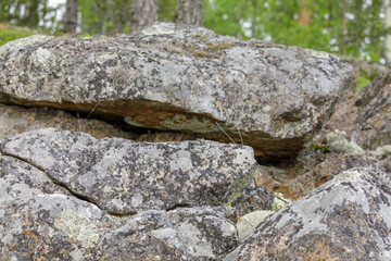 Detailed view of weathered granite boulders with lichen and moss, captured in a forest environment...
