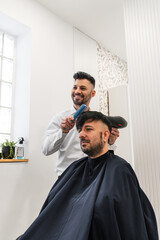 Hairdresser combing and styling a client's hair after applying a nourishing hair treatment in a...