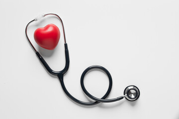 top view, Red heart shape exercise ball with doctor physician's stethoscope on white background. hospital life insurance concept, world heart health day. doctor day