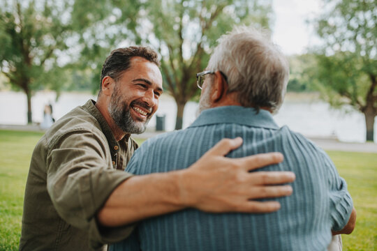 Happy dad and adult son enjoying peaceful afternoon outdoors