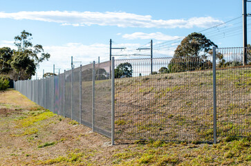 Wire mesh security fencing to a railway corridor in suburban Melbourne, Australia. The sturdy metal...