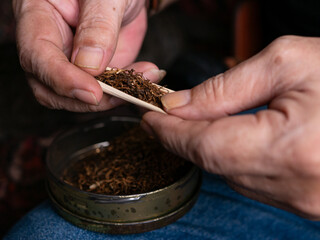 Preparing rolled cigarettes with dried tobacco.