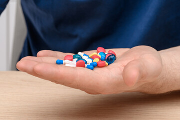 Man holding a huge dose of psychoactive drugs in his hand, mental health problems