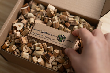 A close-up of a 100% recyclable label being placed on protective packaging made from water hyacinth, a reusable, eco-friendly material that reflects a commitment to sustainable business practices.
