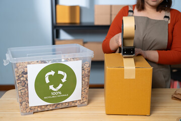 A woman using kraft paper tape to seal a cardboard box in a home-based business, highlighting eco-friendly packaging and sustainable practices in small business operations
