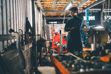 A mechanic stands thoughtfully in a dimly lit workshop filled with tools and machinery, wearing a...