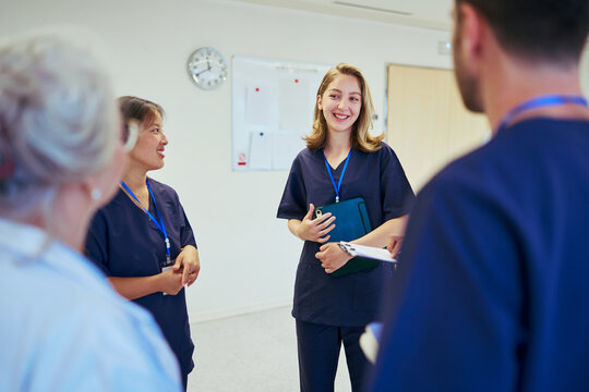 Medical team meeting discussing patient care in hospital corridor