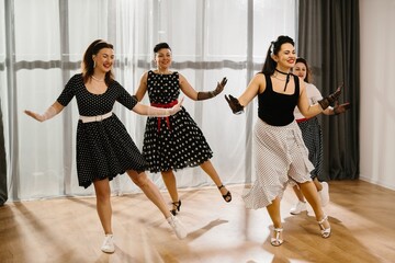 Pinup dancers performing rock and roll routine in dance studio