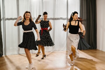 Pinup dancers wearing polka dots swinging in dance studio