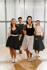 Four pinup dancers wearing polka dots posing in dance studio
