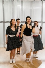 Four pinup dancers wearing polka dots are performing a choreography