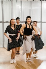 Four pinup dancers wearing polka dots posing in dance studio