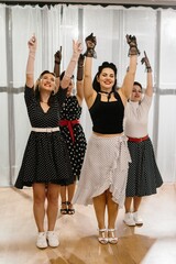 Pinup dancers raising arms in 1950s style choreography