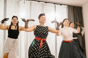 Four women wearing polka dots dancing 1950s style pinup