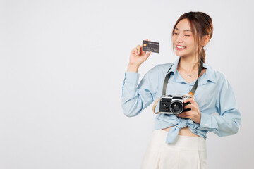 Travel lover with credit card bank and photo camera plans next travel. Cheerful Traveler tourist woman excited for vacation, holding her retro camera and payment card. isolated studio white background