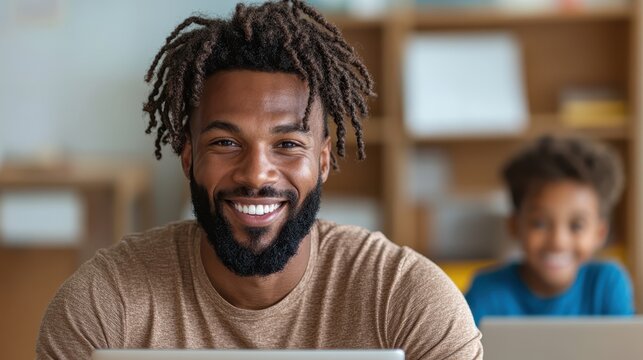 A smiling man engages with a child in a classroom setting, promoting learning and growth through collaboration, showcasing the bond between educator and student.