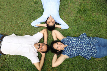 Indian happy family lying down on the grass while fun at park