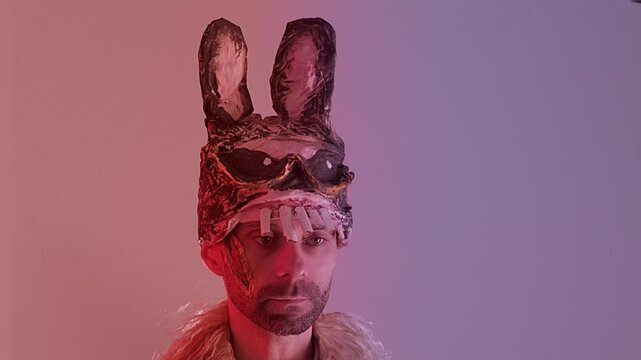 creepy man, young monster guy in cringe in scary bunny mask, juggling pumpkin, concept of Halloween party, theme of fear and horror associated with mask and facial expression, Festive Costumes