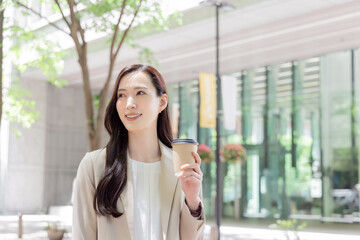 コーヒーをテイクアウトする女性