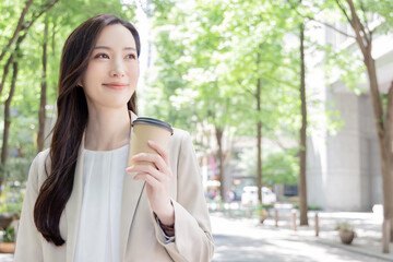 コーヒーをテイクアウトする女性