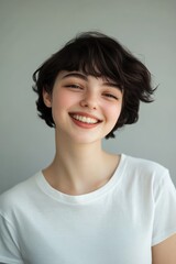 Smiling young woman with short hair in a casual t-shirt, showcasing happiness and confidence, perfect for lifestyle, beauty, or personal branding projects.