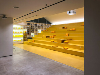 Interior of a large stepped lecture hall with tiered seating for many students.
