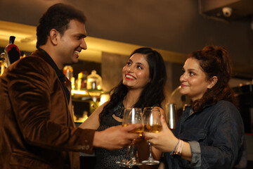 Indian group of friends enjoying evening drinks In bar